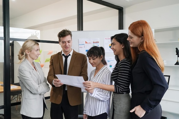 Diversos colegas de trabalho jovens discutindo projeto na mesa no escritório moderno