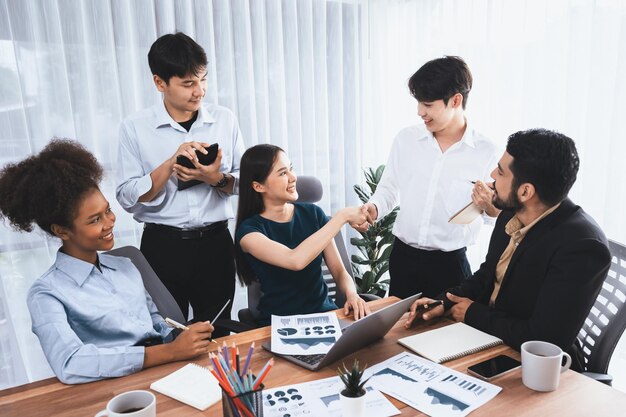 Diversos compañeros de trabajo celebran el éxito con un apretón de manos