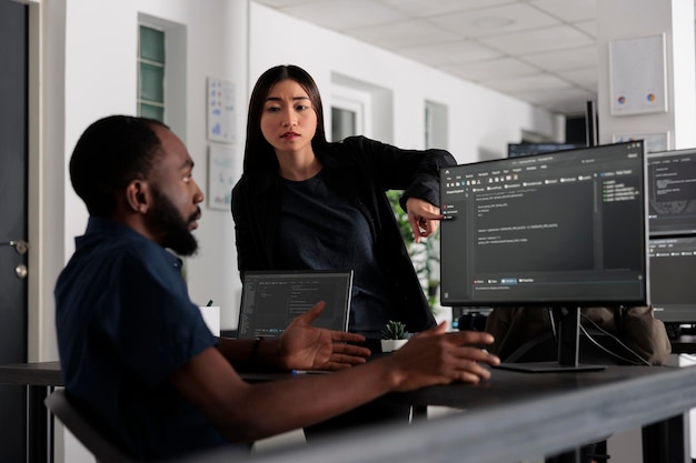 Diversos desarrolladores web que trabajan en el desarrollo de software con código fuente, mirando la computadora. Ingeniero de sistemas escribiendo algoritmo ai en la oficina de big data, computación en la nube en línea. Concepto de programación