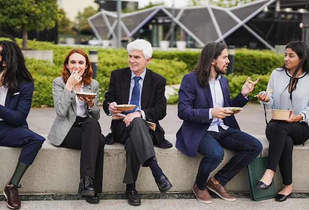 Diversos empresarios comiendo juntos durante el almuerzo fuera de la oficina