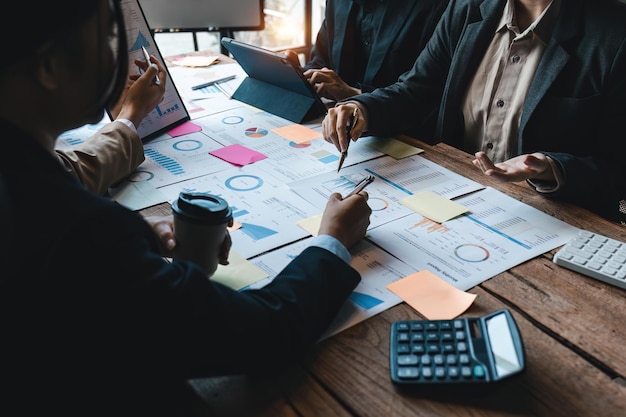 Diversos empresários cooperam, trabalham juntos, discutindo estatísticas financeiras da empresa, colegas multirraciais, funcionários, colaboram com um brainstorm com documento financeiro em uma reunião de close-up