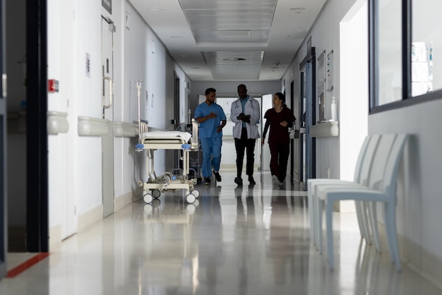 Diversos médicos discutiendo el trabajo y caminando por el corredor en el hospital