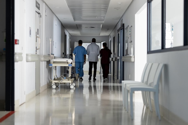 Diversos médicos discutiendo el trabajo y caminando por el corredor en el hospital