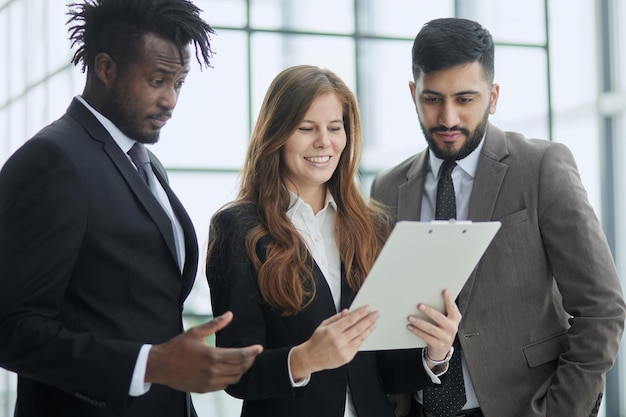 Diversos membros da equipe confiante sorriso equipe de negócios segurando dispositivo de bloco de notas de documento