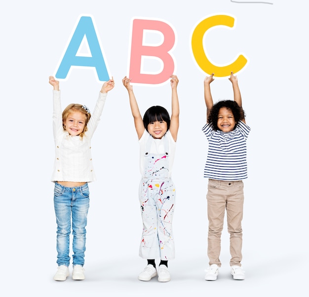 Diversos niños felices aprendiendo el ABC