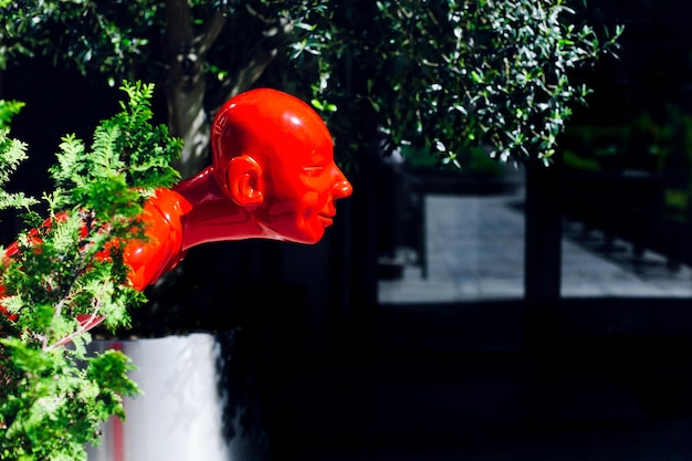 Foto divertida estatua de un hombre rojo en la terraza de un café oriental en la entrada