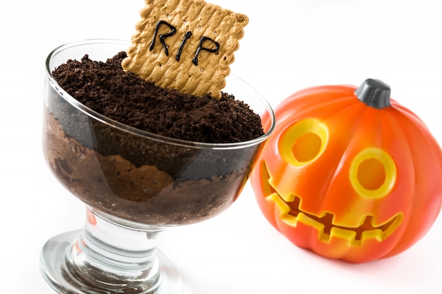 Divertida mousse de chocolate de Halloween con galleta de la tumba y calabaza de halloween aislado en blanco