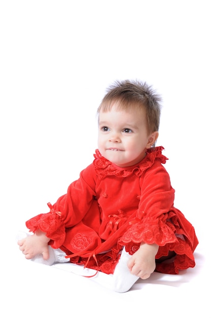 Divertida niña sorprendida en vestidos rojos de Navidad en blanco aislado