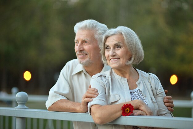 Divertida pareja de ancianos sonriente feliz con flor