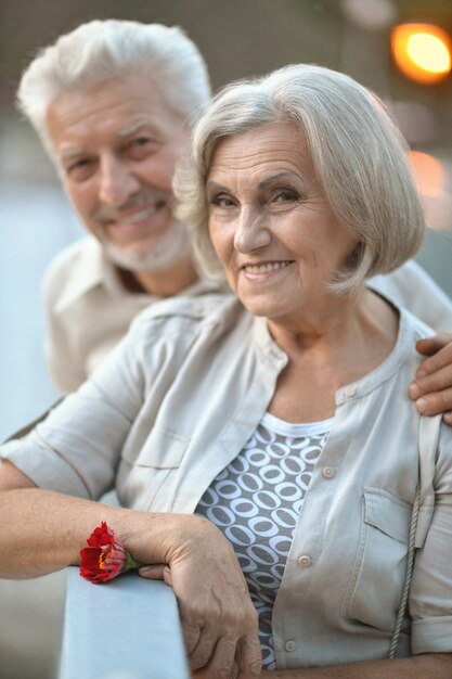 Divertida pareja de ancianos sonriente feliz con flor