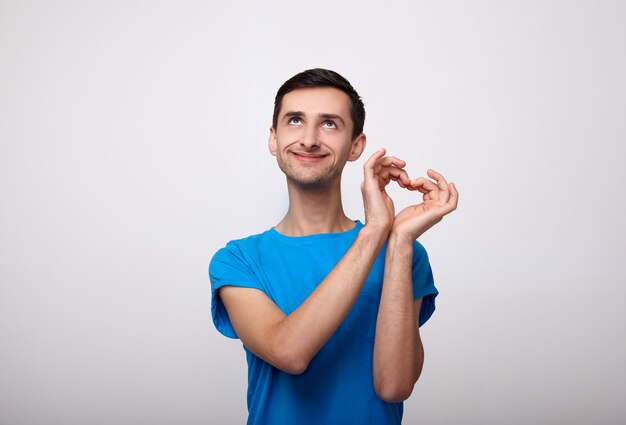 Divertida sonrisa alegre y muestra su corazón con las manos.