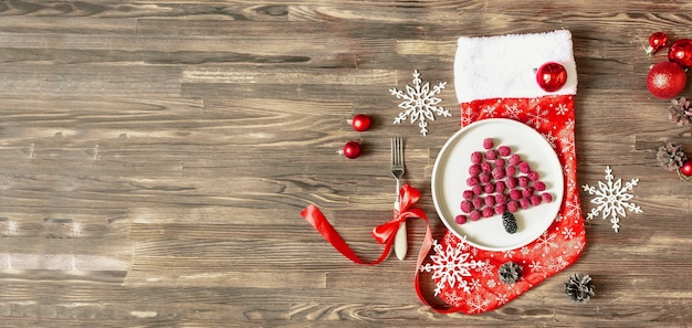 Divertido árbol de Navidad en forma de baya de frambuesa fresca dulce en placa sobre fondo de madera para niños desayuno de niños. comida navideña con adornos de año nuevo. espacio de copia de banner.