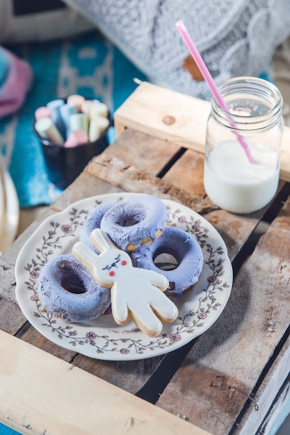 Divertido desayuno con leche, galletas de conejito y donas