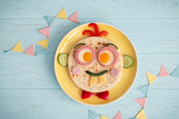 Foto divertido desayuno para niños con sándwich en forma de cara