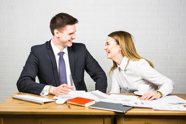 Divertido empresario contando un chiste durante la pausa café