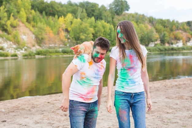 Divertido hombre y mujer con gato en natural