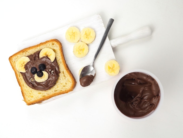 Divertido lindo oso cara sándwich pan tostado con chocolate para untar plátano y arándanos