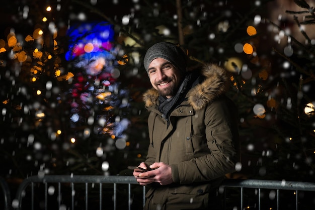 Divertindo-se em uma fada de Natal jovem alegre vestido de quente está de pé no mercado de férias