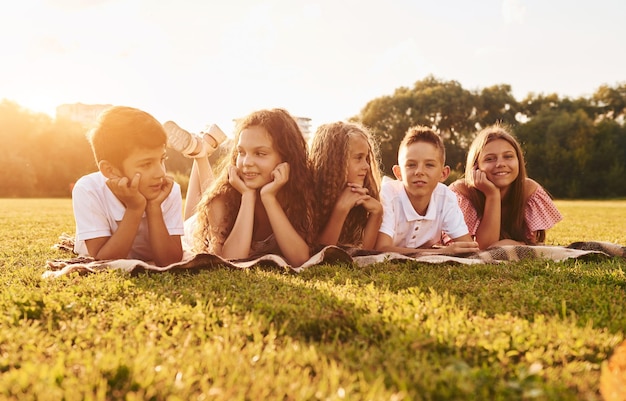 Divertirse Grupo de niños felices está al aire libre en el campo deportivo durante el día