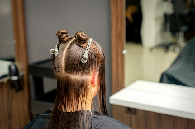 Dividió el cabello de las mujeres en secciones con clips en la barbería.