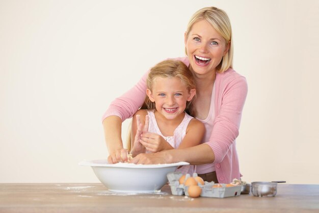 Divirtiéndose en la cocina Retrato de una madre y su hija divirtiéndose mientras hornean juntas