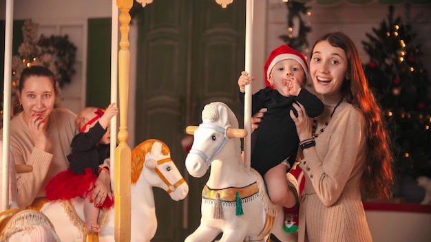 Divirtiéndose con decoración navideña dos madres con sus bebés