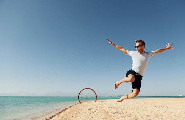 Divirtiéndose El joven europeo tiene vacaciones y disfruta del tiempo libre en la playa del mar