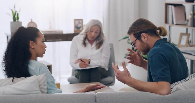 Divórcio de estresse e casal em aconselhamento com psicólogo ouvindo problemas e conflitos no casamento Problemas de psicologia e terapeuta ajudando uma jovem e um parceiro zangado na terapia