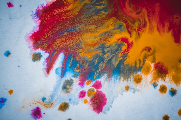 Divórcios e pingos de tinta vermelho, laranja, amarelo, azul fundo abstrato desfocado em um plano de fundo de papel branco macro close-up de superfície com efeito de filtro de tom