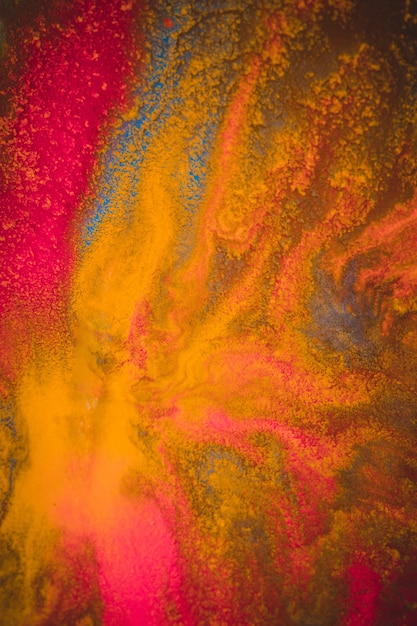 Divorcios y goteos de pintura rojo, naranja, amarillo, azul fondo abstracto borroso en una macro de primer plano de superficie de plano de fondo de papel blanco con efecto de tono de filtro