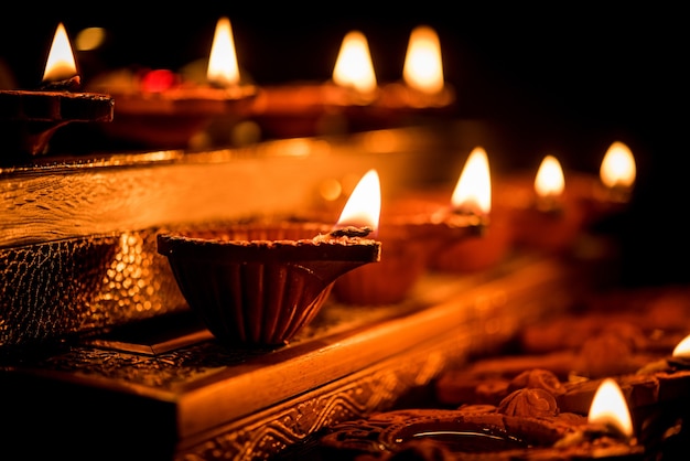 Diwali diya o iluminación en la noche con regalos, flores sobre una escena cambiante