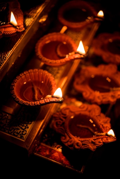 Diwali diya o iluminación en la noche con regalos, flores sobre una escena cambiante