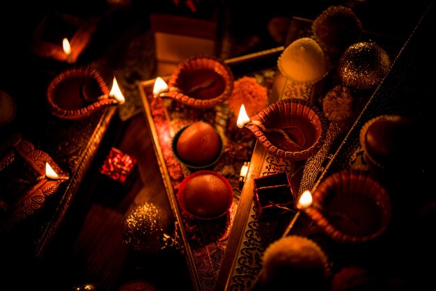 Diwali Diya oder Beleuchtung in der Nacht mit Geschenken, Blumen über einer stimmungsvollen Szene