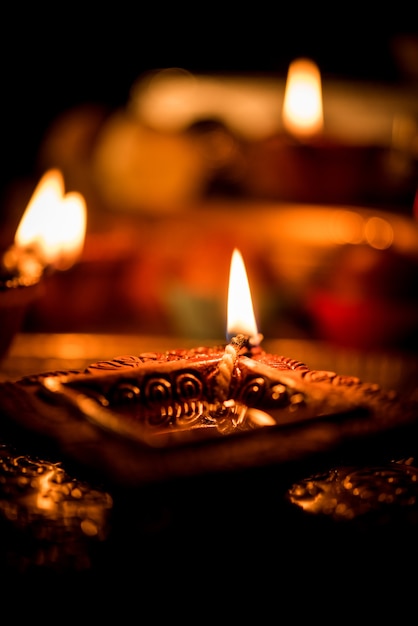 Diwali diya ou iluminação à noite com presentes, flores em um cenário sombrio