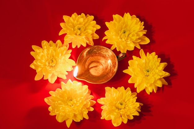 Diwali Indian Light Festival Diya lámpara de aceite y flores amarillas sobre fondo rojo Celebración hindú tradicional