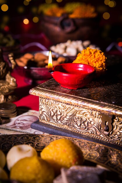 Diwali y preparación para Laxmi o Lakshmi Pooja con elementos como diya, billetes, dulces, flores, bocadillos, haldi y kumkum