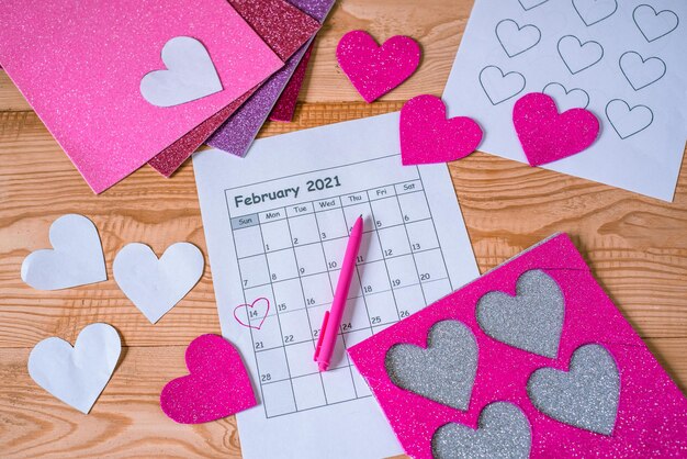 Foto diy corazones y calendario con el 14 de febrero rodeado.