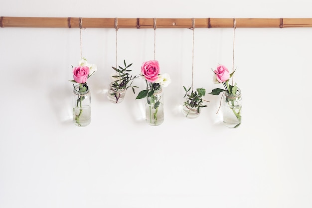 Foto diy decoração de férias elegantes flores em vasos frascos são suspensos da parede branca na sala