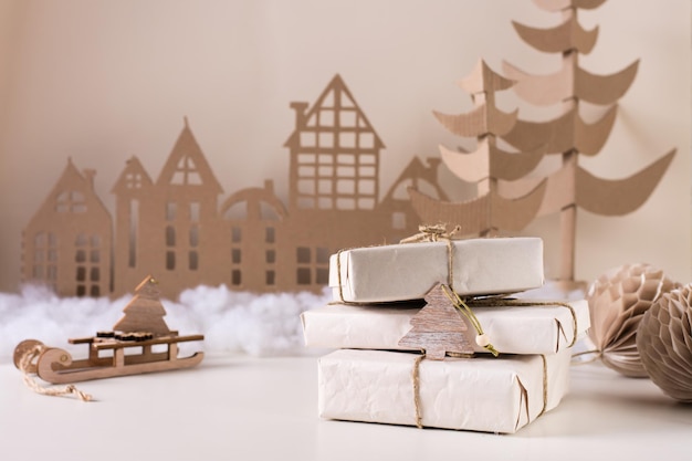 DIY decoración navideña para el hogar una pila de regalos en papel artesanal un árbol de cartón y una casa Hecho a mano