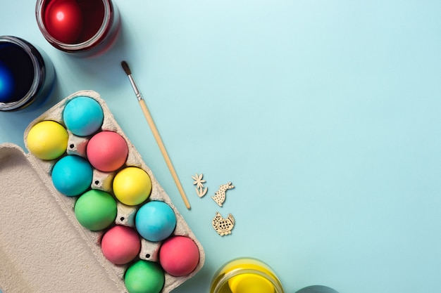 Foto diy ei färbeset, tablett mit farbigen ostereiern auf pastellblauem hintergrund. flach liegen.