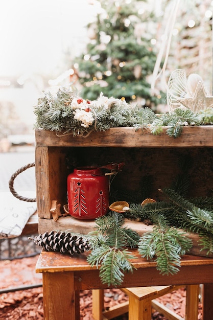 DIY natürliche Weihnachtsdekoration und rote Kerzenlaterne im Freien Tannenzweig mit Tannenzapfen in Schachtel