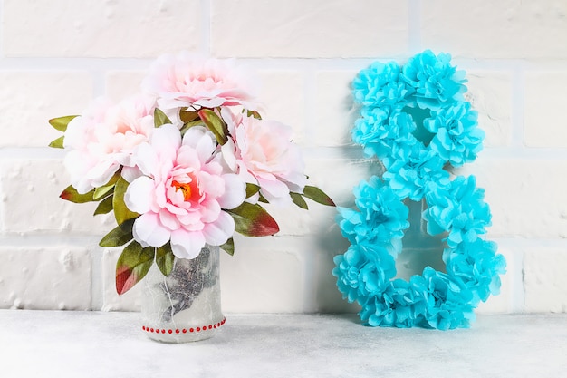 Diy oito fez papelão decorado flor artificial feita de tecido azul guardanapo de papel branco fundo.