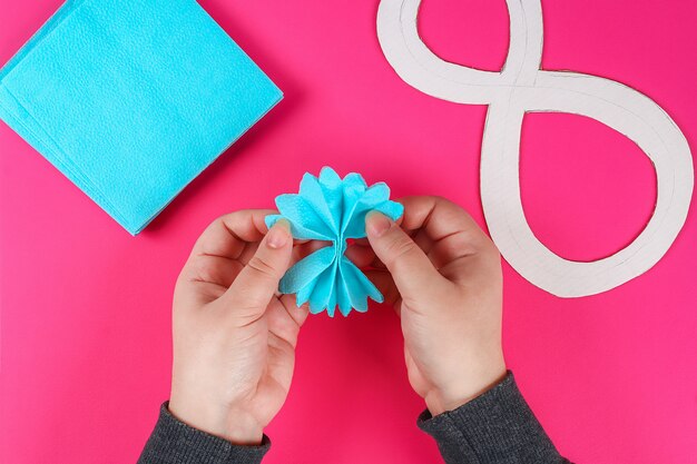 Foto diy oito fez papelão decorado flor artificial feita de tecido de papel azul guardanapo fundo rosa.