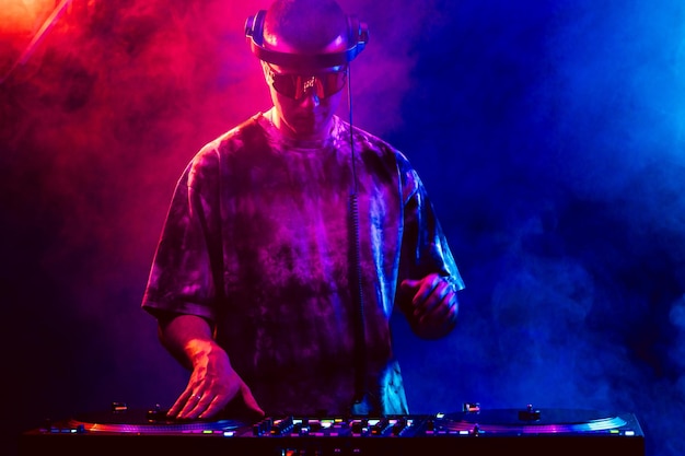 DJ de club tocando música en una fiesta con gafas de sol