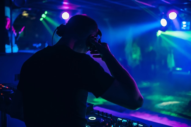 Dj com fones de ouvido executa em um concerto de música