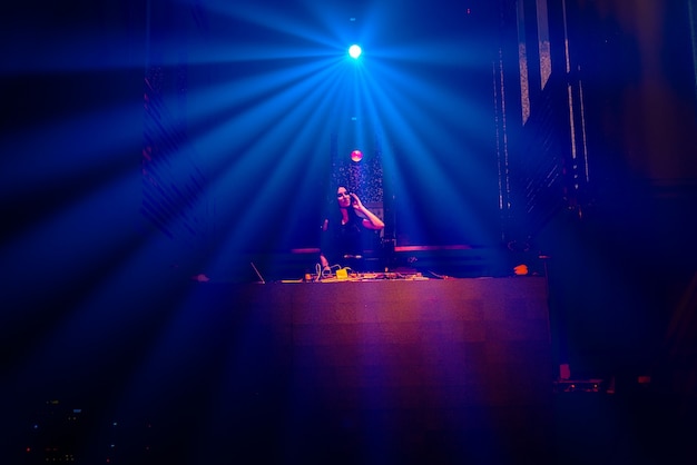 DJ en el escenario en la discoteca discoteca mezclando ritmo de música techno