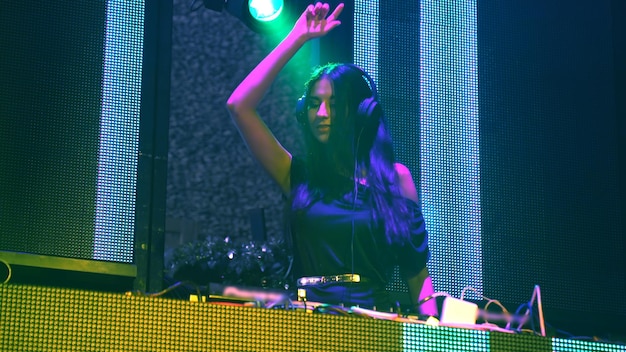DJ en el escenario en la discoteca discoteca mezclando ritmo de música techno