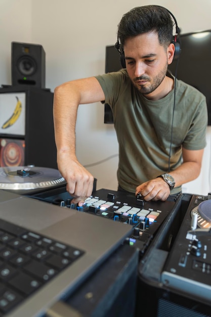 El DJ se está divirtiendo mientras presiona los botones de la consola para crear música