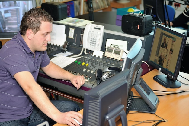 DJ de la estación de radio leyendo noticias e información