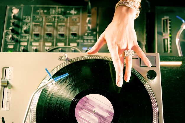 DJ femenina en el tocadiscos en el Club